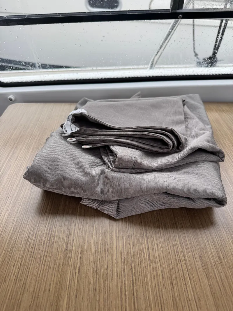 Slide: The Image of Folded gray fabric on a wooden surface inside a 2020 Jeanneau NC Sport 795 boat. - 46