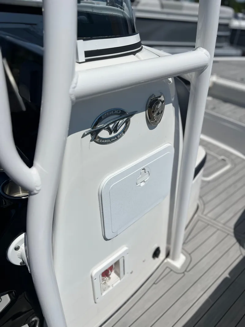 Slide: The Image of 2022 Tidewater 2500 Carolina Bay boat console with logo and storage compartment. - 11