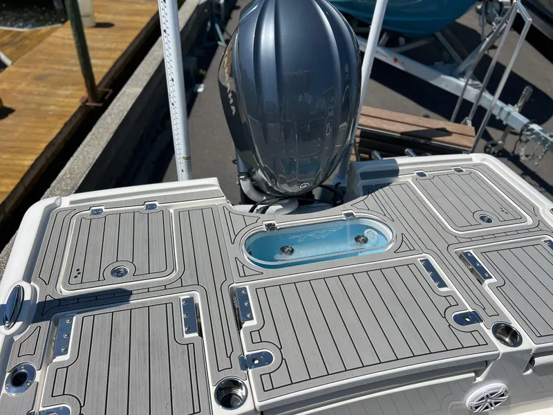 Slide: The Image of 2022 Tidewater 2500 Carolina Bay boat deck with outboard motor and storage compartments. - 14
