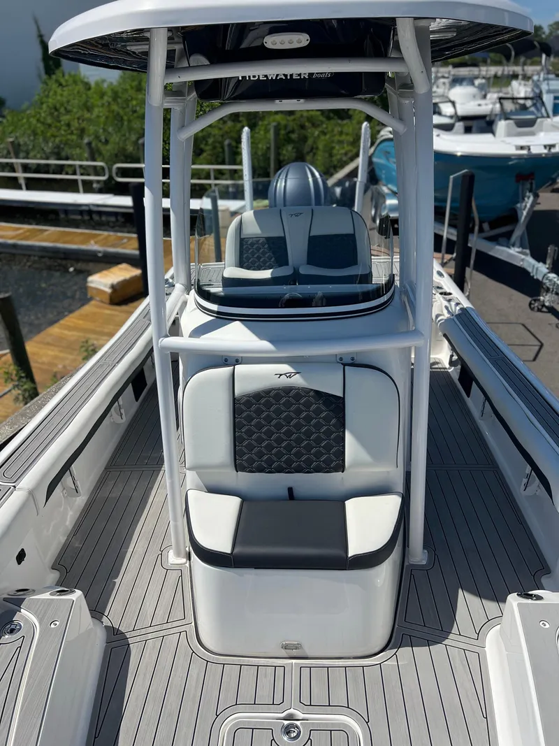 Slide: The Image of 2022 Tidewater 2500 Carolina Bay boat interior with seating and console, docked at marina. - 9
