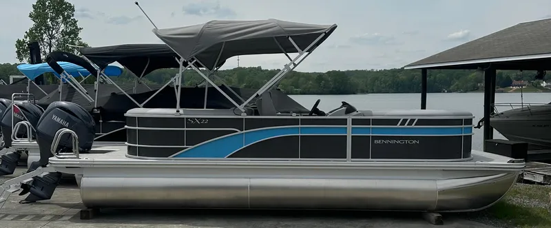 Slide: The Image of 2025 Bennington 22 SXSR pontoon boat docked by a lake with Yamaha engines. - 3