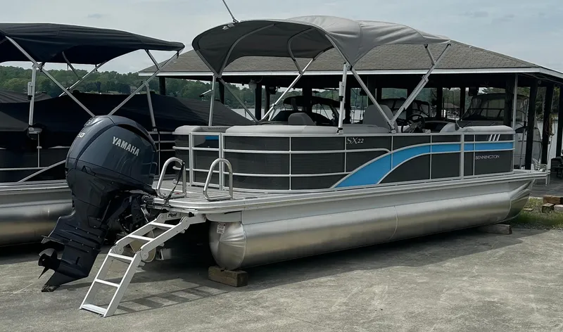 Slide: The Image of 2025 Bennington 22 SXSR pontoon boat with Yamaha outboard motor, docked under canopy. - 4
