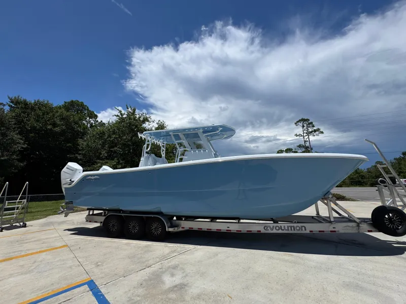 Slide: The Image of 2026 Invincible 33 Catamaran on trailer under blue sky. - 10