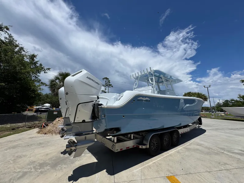 Slide: The Image of 2026 Invincible 33 Catamaran on trailer, featuring dual Mercury outboard engines, under a clear blue sky. - 13