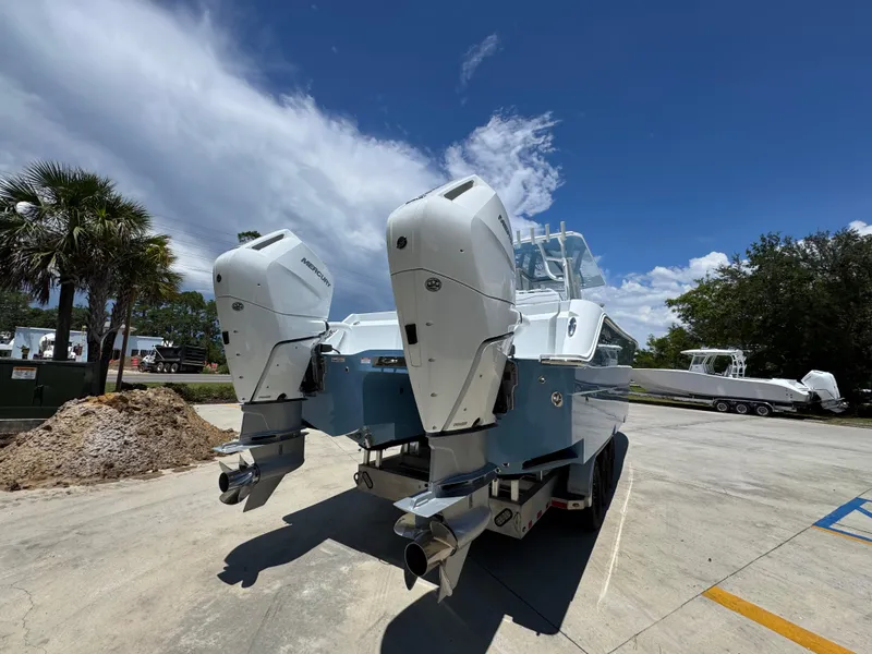 Slide: The Image of 2026 Invincible 33 Catamaran with dual outboard motors on a sunny day. - 14