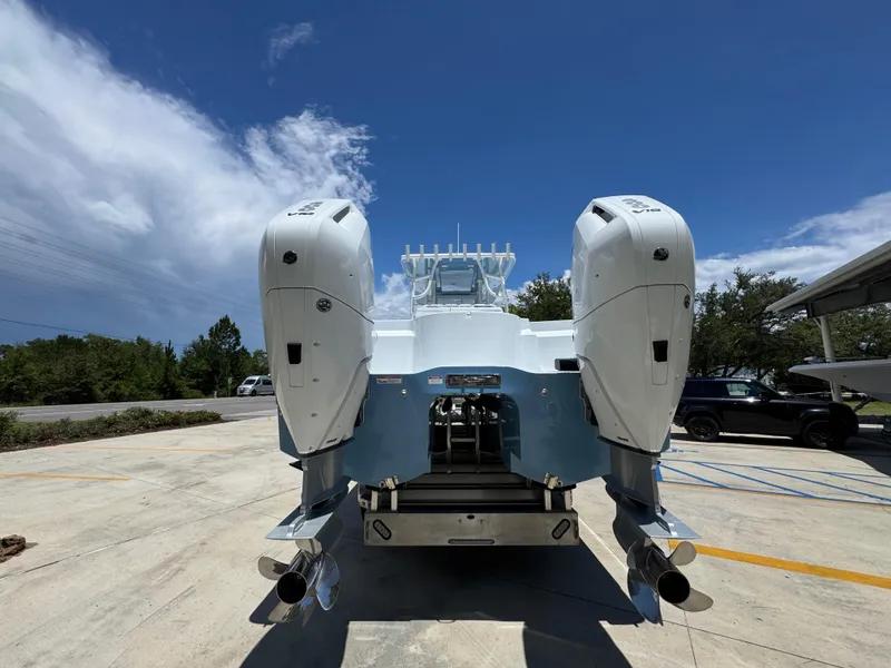 Slide: The Image of 2026 Invincible 33 Catamaran with dual outboard engines, parked under a clear blue sky. - 16
