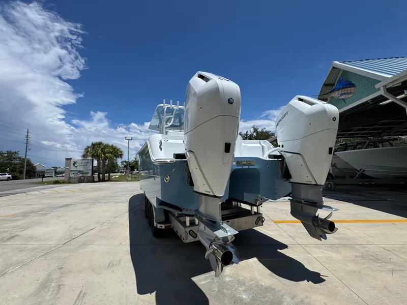 Slide: The Image of 2026 Invincible 33 Catamaran with dual outboard engines in a sunny marina setting. - 17