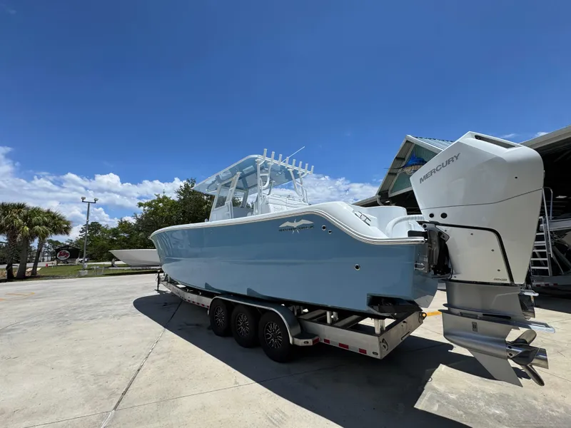 Slide: The Image of 2026 Invincible 33 Catamaran with Mercury engines on a trailer under clear blue sky. - 18