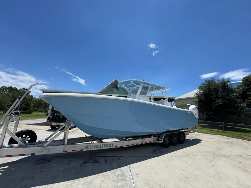 Slide: The Image of 2026 Invincible 33 Catamaran on trailer under clear blue sky. - 3