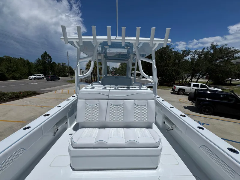 Slide: The Image of 2026 Invincible 33 Catamaran with sleek white seating and modern design, parked outdoors. - 35