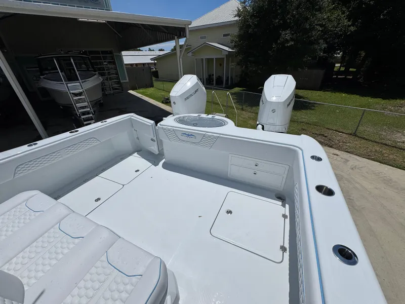 Slide: The Image of 2026 Invincible 33 Catamaran with dual Mercury engines, docked outdoors. - 36