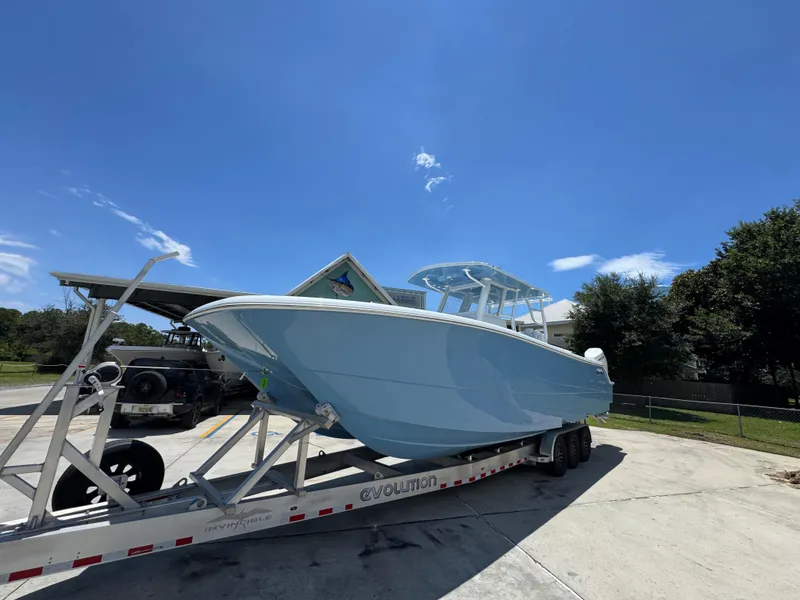 Slide: The Image of 2026 Invincible 33 Catamaran on trailer under clear blue sky. - 4
