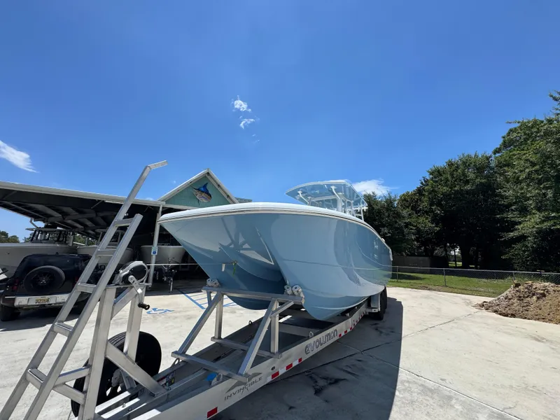 Slide: The Image of 2026 Invincible 33 Catamaran on trailer under clear blue sky. - 5