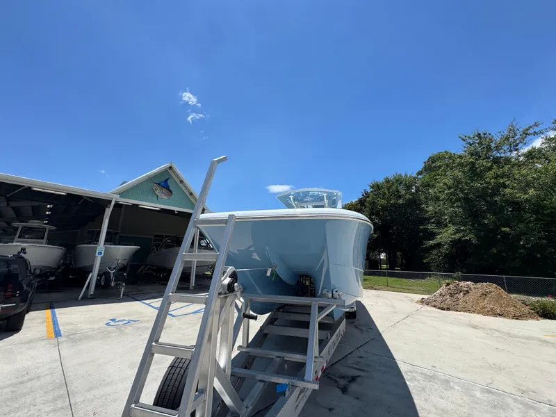 Slide: The Image of 2026 Invincible 33 Catamaran on trailer under clear blue sky. - 6