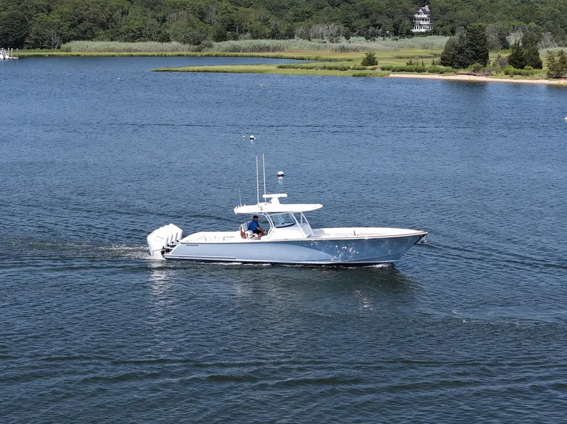 Slide: The Image of 2026 Valhalla Boatworks V-41 cruising on a serene lake with lush green shoreline. - 20