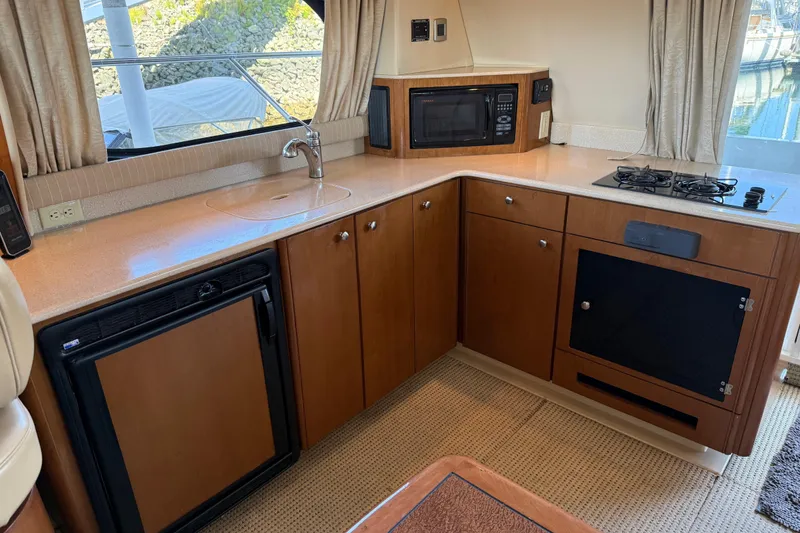 Slide: The Image of 2005 Meridian 341 Sedan yacht kitchen with stove, microwave, and sink. - 4