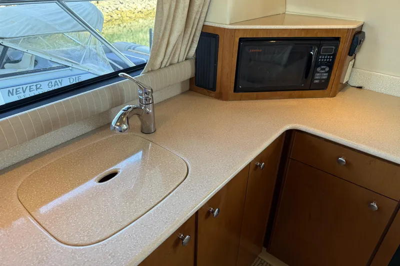 Slide: The Image of 2005 Meridian 341 Sedan kitchen with sink, microwave, and wooden cabinetry. - 5