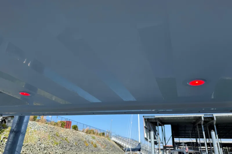 Slide: The Image of Underneath view of a 2005 Meridian 341 Sedan with red lights, docked near a marina. - 50