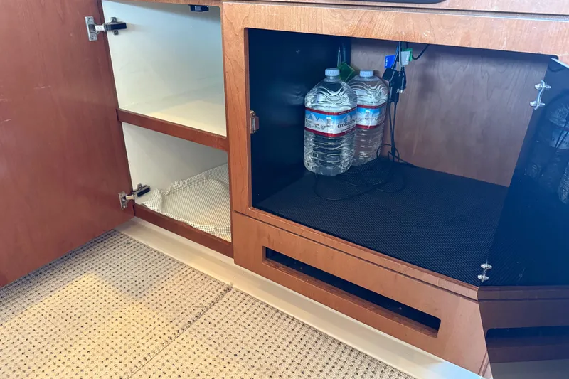Slide: The Image of Cabinet interior of 2005 Meridian 341 Sedan with water bottles and storage space. - 8