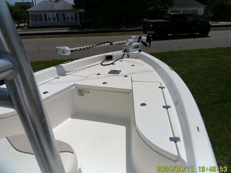 Slide: The Image of 2017 NauticStar 2140 Sport boat interior with trolling motor, parked on grass. - 11