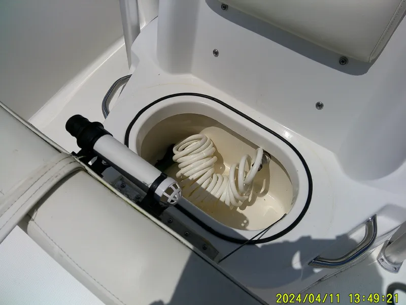 Slide: The Image of 2017 NauticStar 2140 Sport boat with coiled hose in storage compartment. - 15