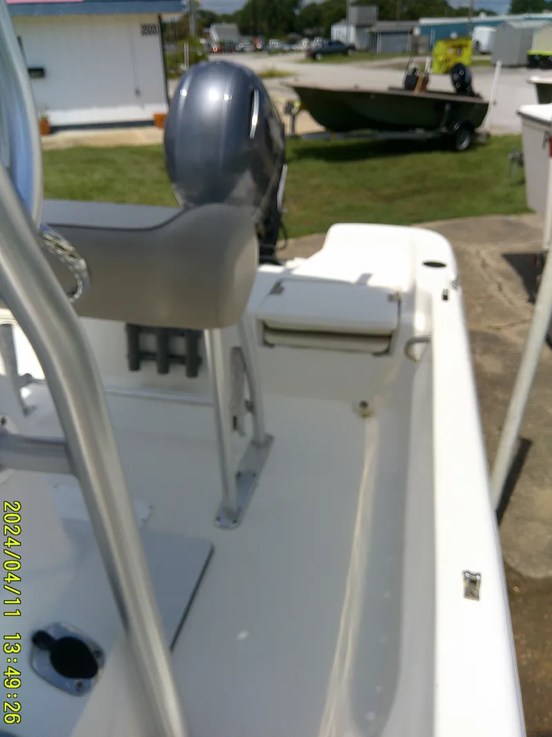 Slide: The Image of 2017 NauticStar 2140 Sport boat interior with motor, parked outdoors. - 16