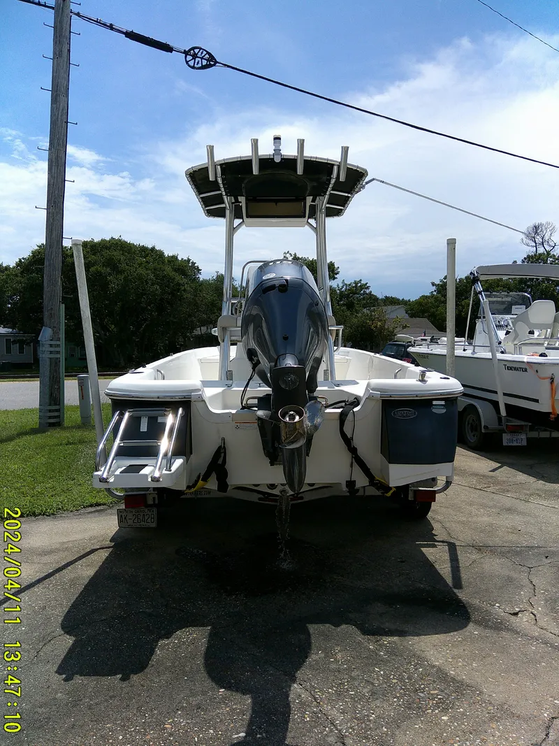 Slide: The Image of 2017 NauticStar 2140 Sport boat with outboard motor, parked on a driveway. - 3