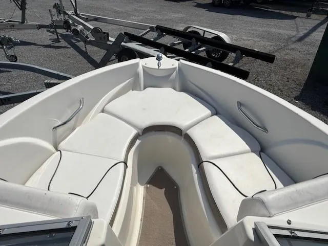 Slide: The Image of Bow seating area of a 2011 Larson LX 850 boat, with white cushions and metal railings. - 7