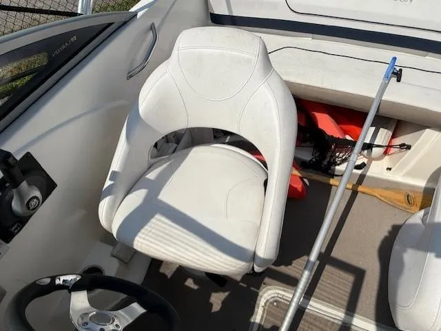 Slide: The Image of White captain's chair in 2011 Larson LX 850 boat cockpit, with steering wheel and equipment. - 8