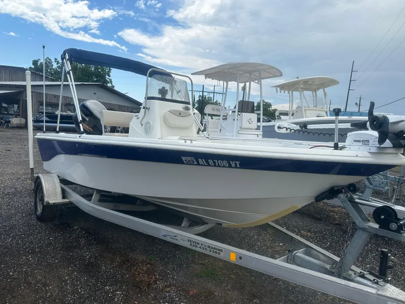 Slide: The Image of 2015 NauticStar 1810 NauticBay boat on trailer, parked outdoors under cloudy sky. - 14