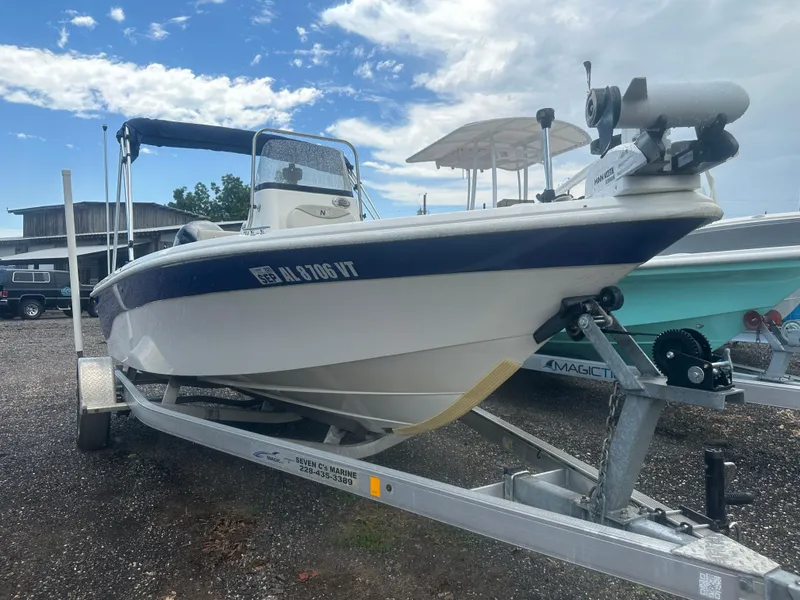 Slide: The Image of 2015 NauticStar 1810 NauticBay boat on trailer, parked outdoors under a cloudy sky. - 16
