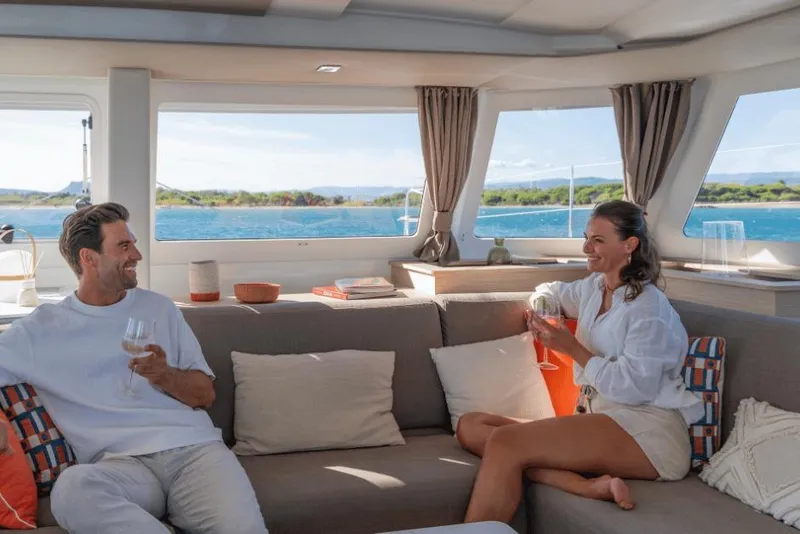Slide: The Image of Couple enjoying wine on a 2026 Fountaine Pajot 44 yacht interior. - 19