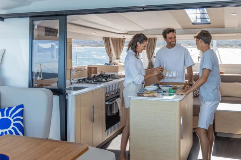Slide: The Image of People enjoying a meal in the modern kitchen of a 2026 Fountaine Pajot 44 yacht. - 20
