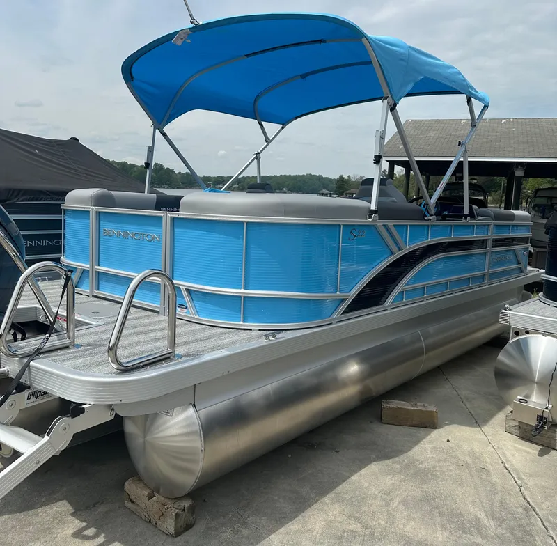 Slide: The Image of 2025 Bennington 22 SSR pontoon boat with blue canopy and sleek design. - 1