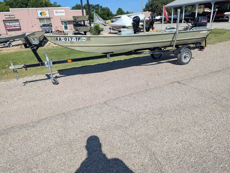 Slide: The Image of 1983 Lowe 16 Lake Jon boat on trailer, parked outdoors in a lot. - 1