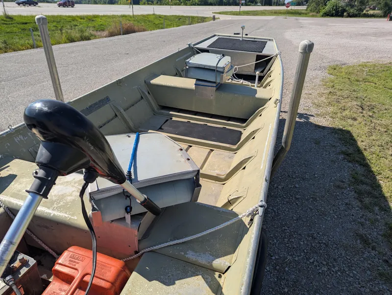 Slide: The Image of 1983 Lowe 16 Lake Jon boat on trailer, featuring motor and storage compartments. - 10