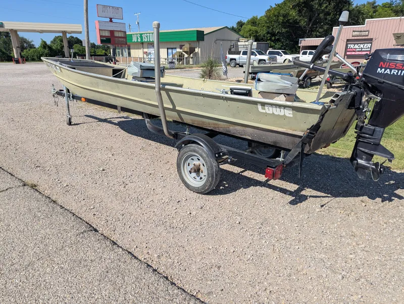 Slide: The Image of 1983 Lowe 16 Lake Jon boat on trailer with Nissan Marine motor, parked outdoors. - 3