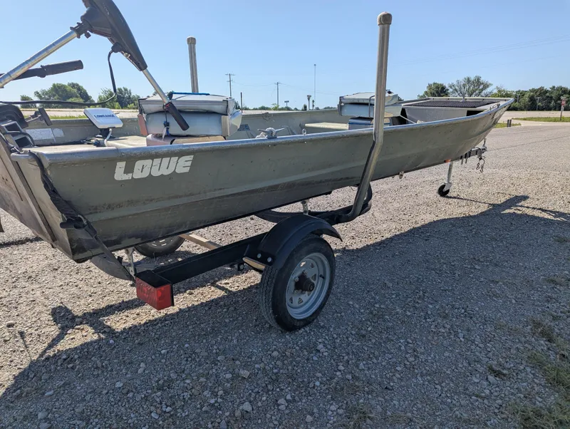 Slide: The Image of 1983 Lowe 16 Lake Jon boat on trailer, parked on gravel surface. - 5