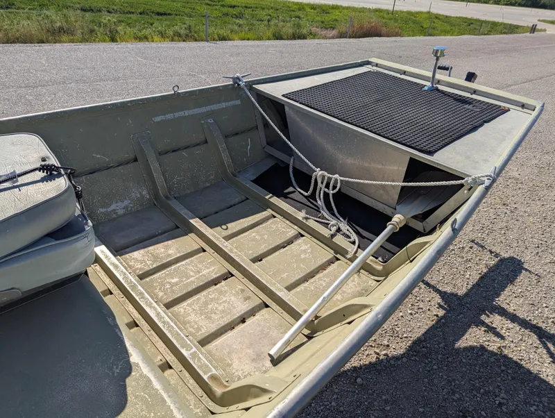 Slide: The Image of 1983 Lowe 16 Lake Jon boat interior with seating and storage on a sunny day. - 8