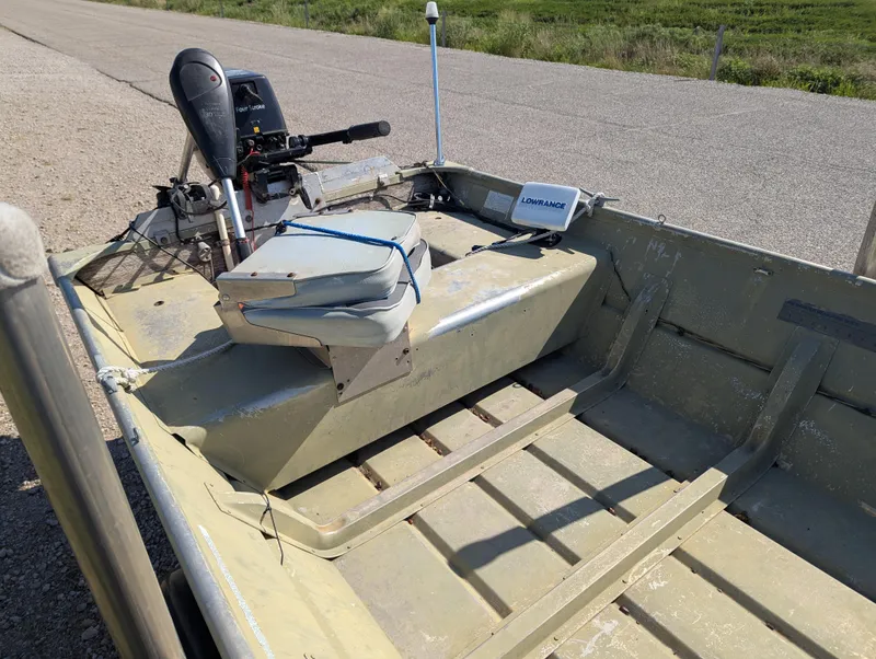 Slide: The Image of 1983 Lowe 16 Lake Jon boat with motor and seat on a rural road. - 9