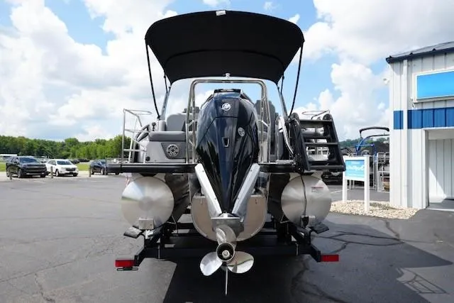 Slide: The Image of 2026 Harris Solstice 250 pontoon boat with outboard motor, parked outdoors. - 6