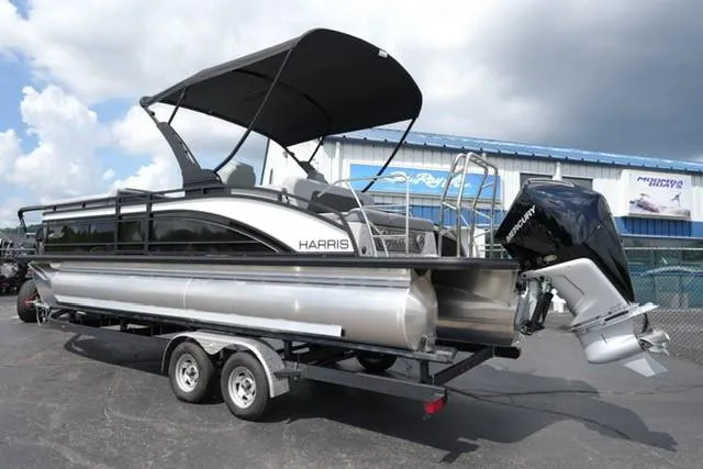 Slide: The Image of 2026 Harris Solstice 250 pontoon boat on trailer, featuring a sleek design and powerful outboard motor. - 7