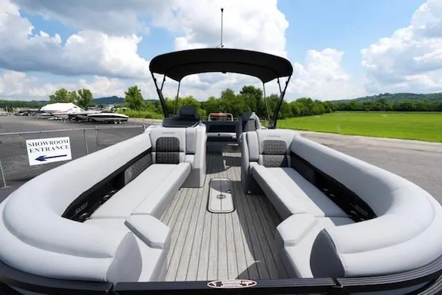 Slide: The Image of 2026 Harris Solstice 250 pontoon boat with spacious seating, docked outdoors under a blue sky. - 8