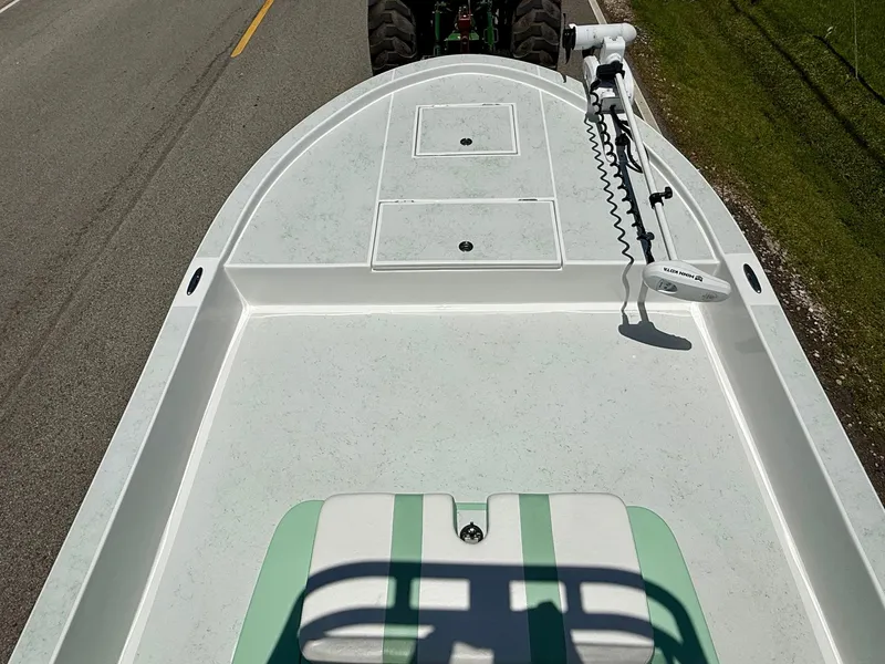 Slide: The Image of 2023 Shallow Sport 24 Sport boat on road, featuring spacious deck and trolling motor. - 12