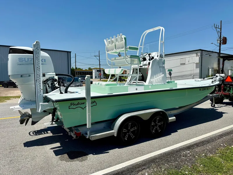 Slide: The Image of 2023 Shallow Sport 24 Sport boat with Suzuki engine on a trailer, parked outdoors. - 4