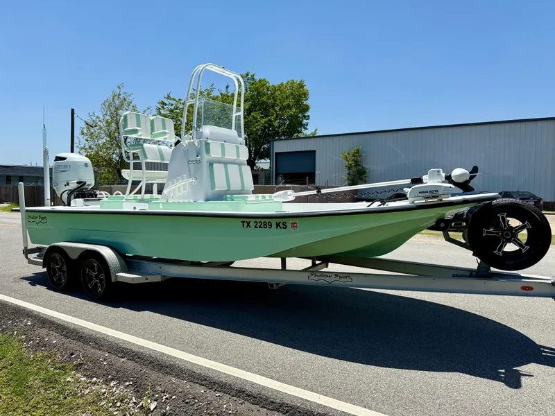 Slide: The Image of 2023 Shallow Sport 24 Sport boat on trailer, mint green, parked on road. - 5