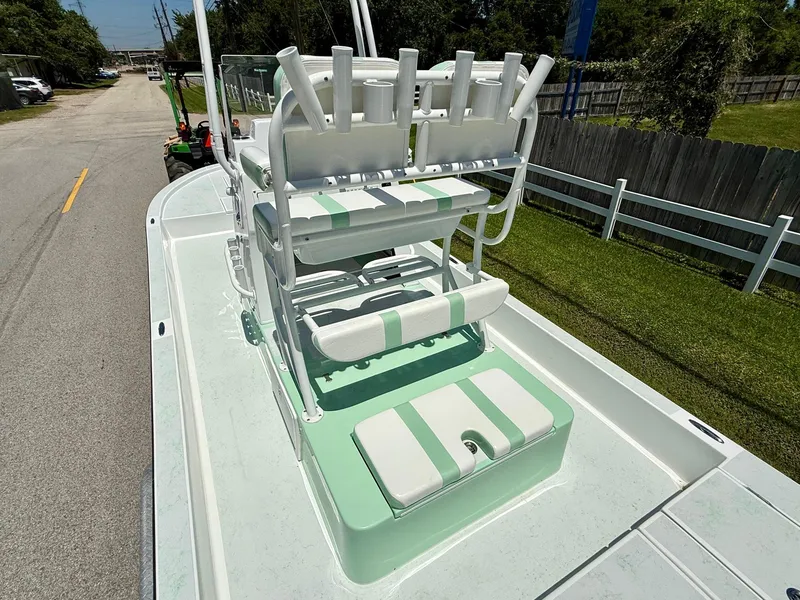 Slide: The Image of 2023 Shallow Sport 24 Sport boat with green and white seating on a sunny day. - 8