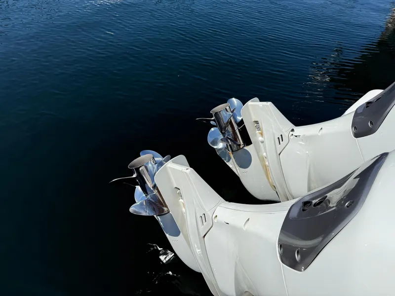 Slide: The Image of Twin outboard motors on a 2022 Jeanneau NC 1095 Coupe, reflecting on calm water. - 13