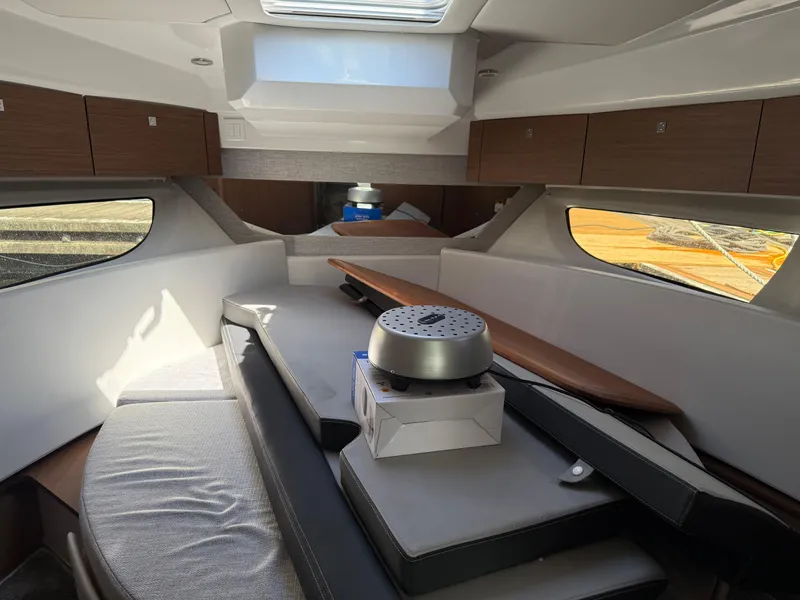 Slide: The Image of Interior of 2022 Jeanneau NC 1095 Coupe boat, featuring modern seating and storage. - 6