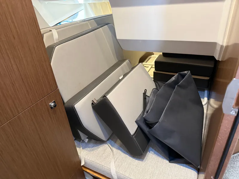 Slide: The Image of Interior storage area of 2022 Jeanneau NC 1095 Coupe with cushions and bags. - 7